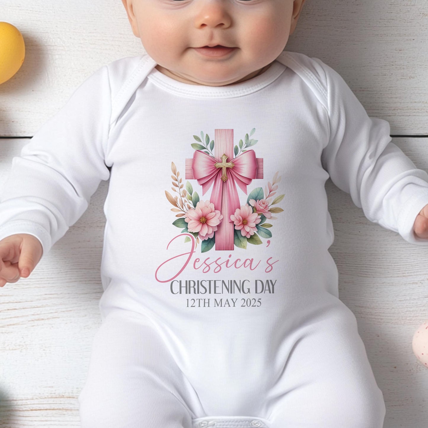 Personalised pink cross christening outfit for baby laid flat showing the full design