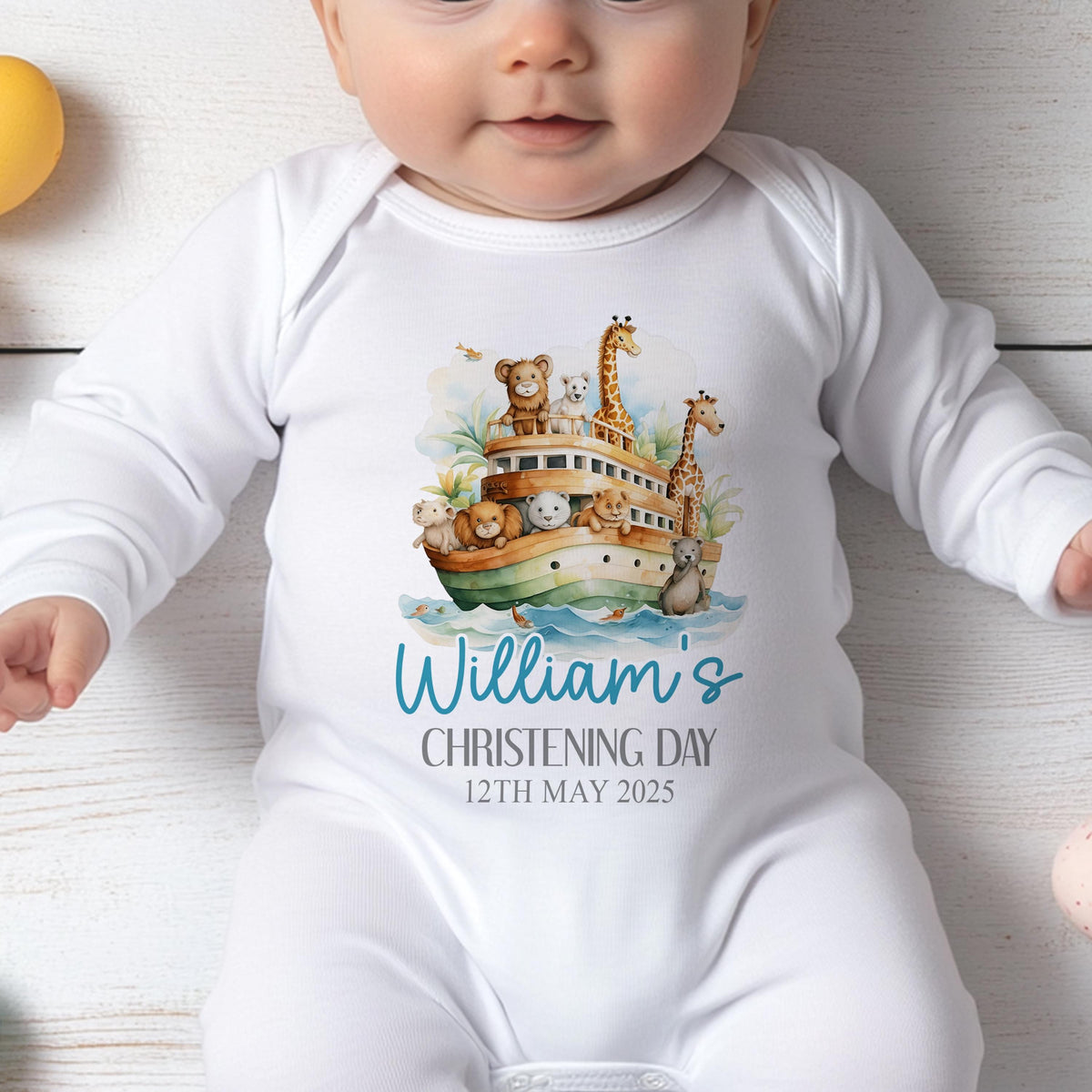 Personalised Noah's Ark christening sleepsuit, printed with baby's name and christening date.