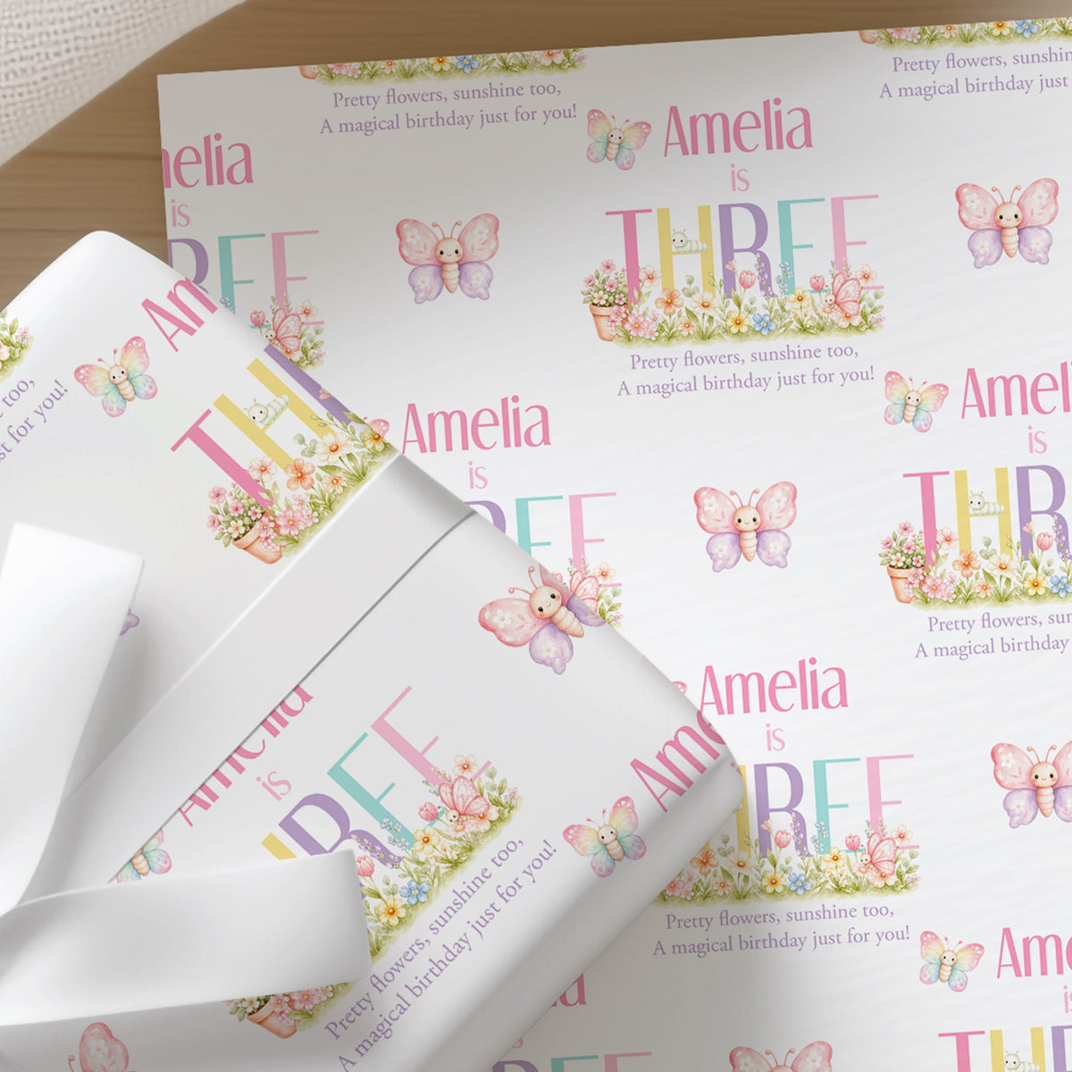 Pastel butterfly and flower wrapping paper pattern personalised with the name Amelia and the phrase 'A magical birthday just for you'.