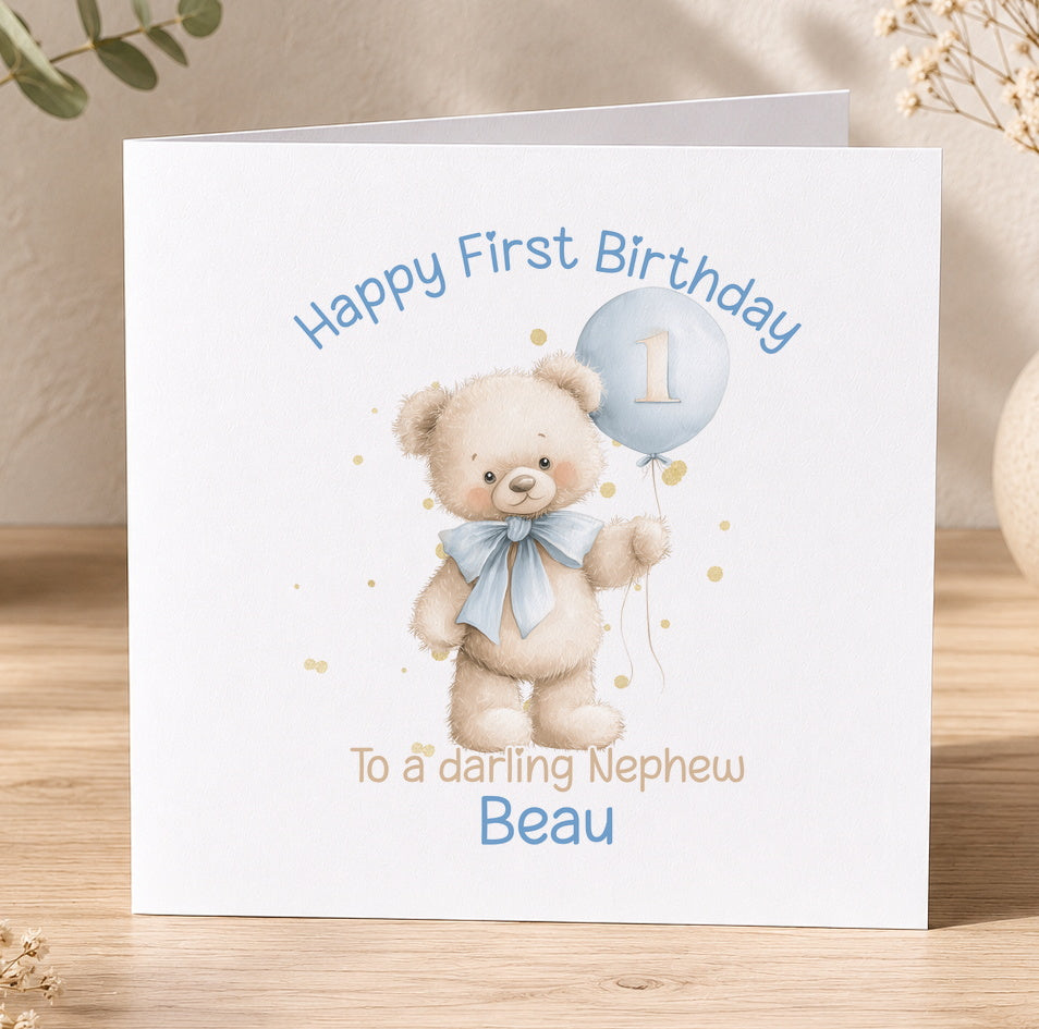 White 1st birthday card for a baby boy featuring a teddy bear holding a blue balloon