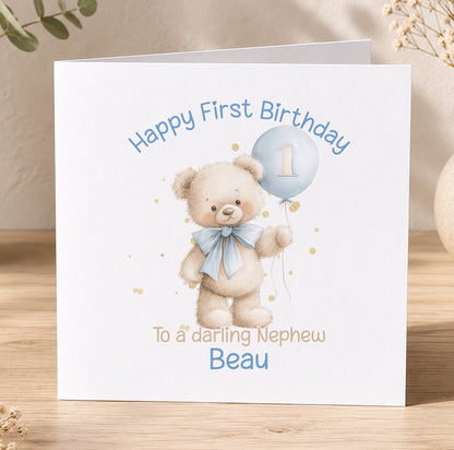 White 1st birthday card for a baby boy featuring a teddy bear holding a blue balloon