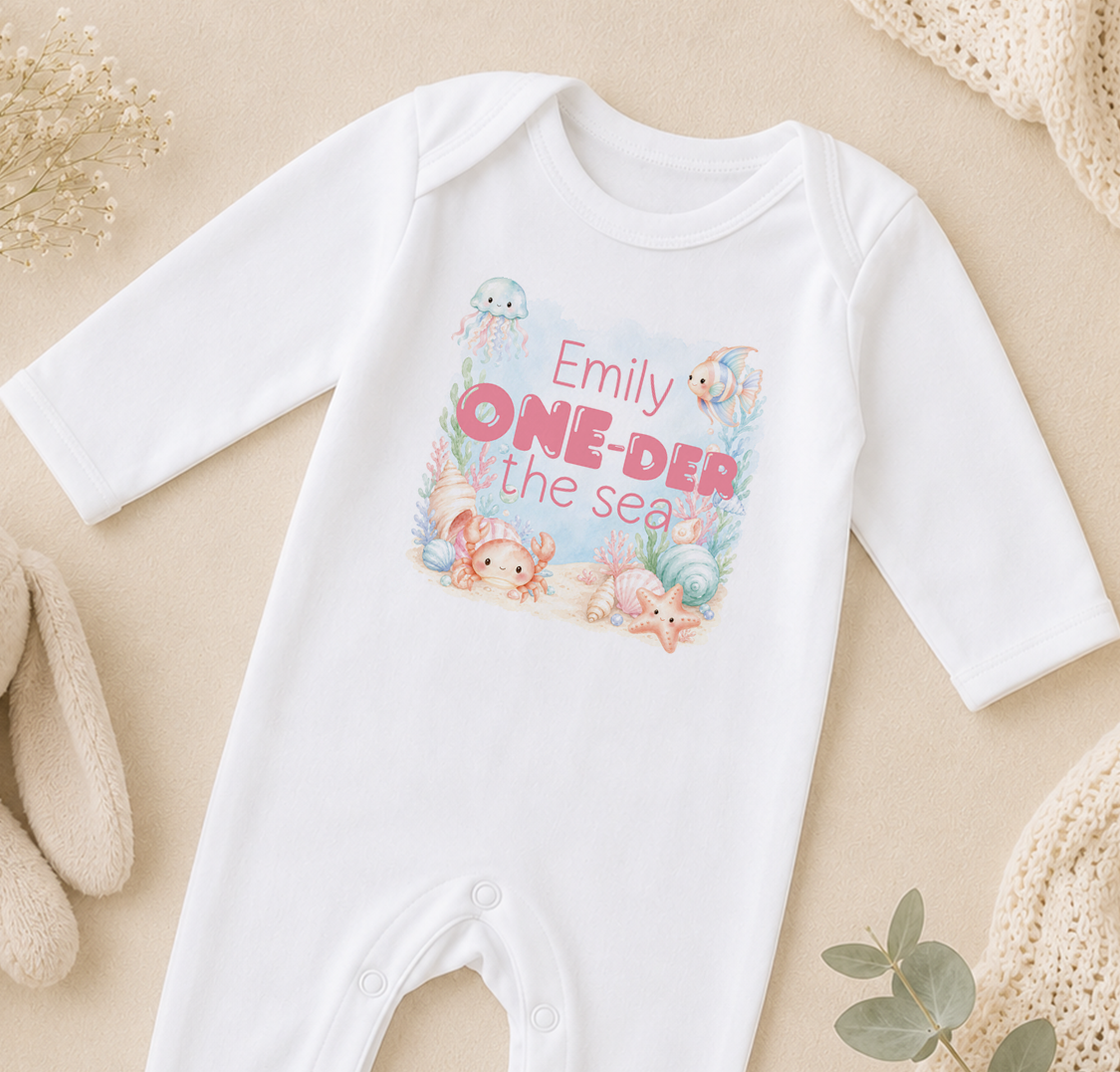 White baby onesie personalised with sea creature illustrations and the name 'Emilly'