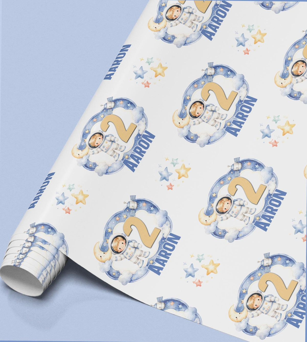 A roll of wrapping paper with a repeating pattern of a boy in a spacesuit, stars and clouds, shown here personalised with the age 2