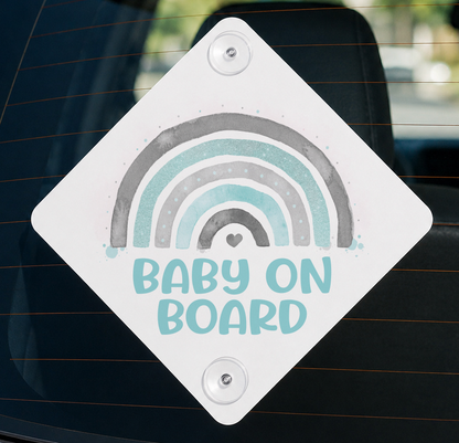 White diamond-shaped aluminium Baby on Board car window sign with an aqua, grey and rainbow design