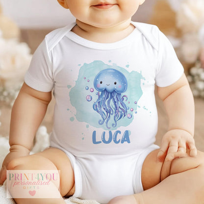 Flat lay of the personalised jellyfish baby outfit range, showing the ocean-theme print and custom name.