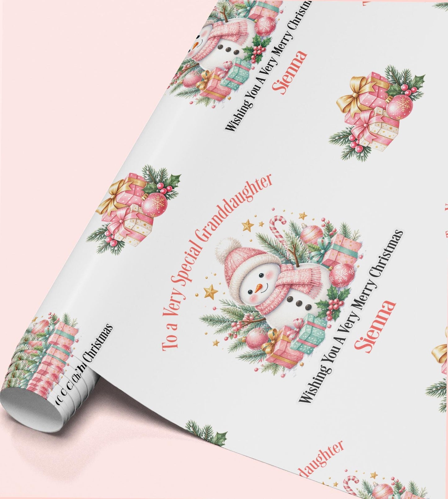 Rolled sheet of personalised pink snowman Christmas wrapping paper with a name and relation