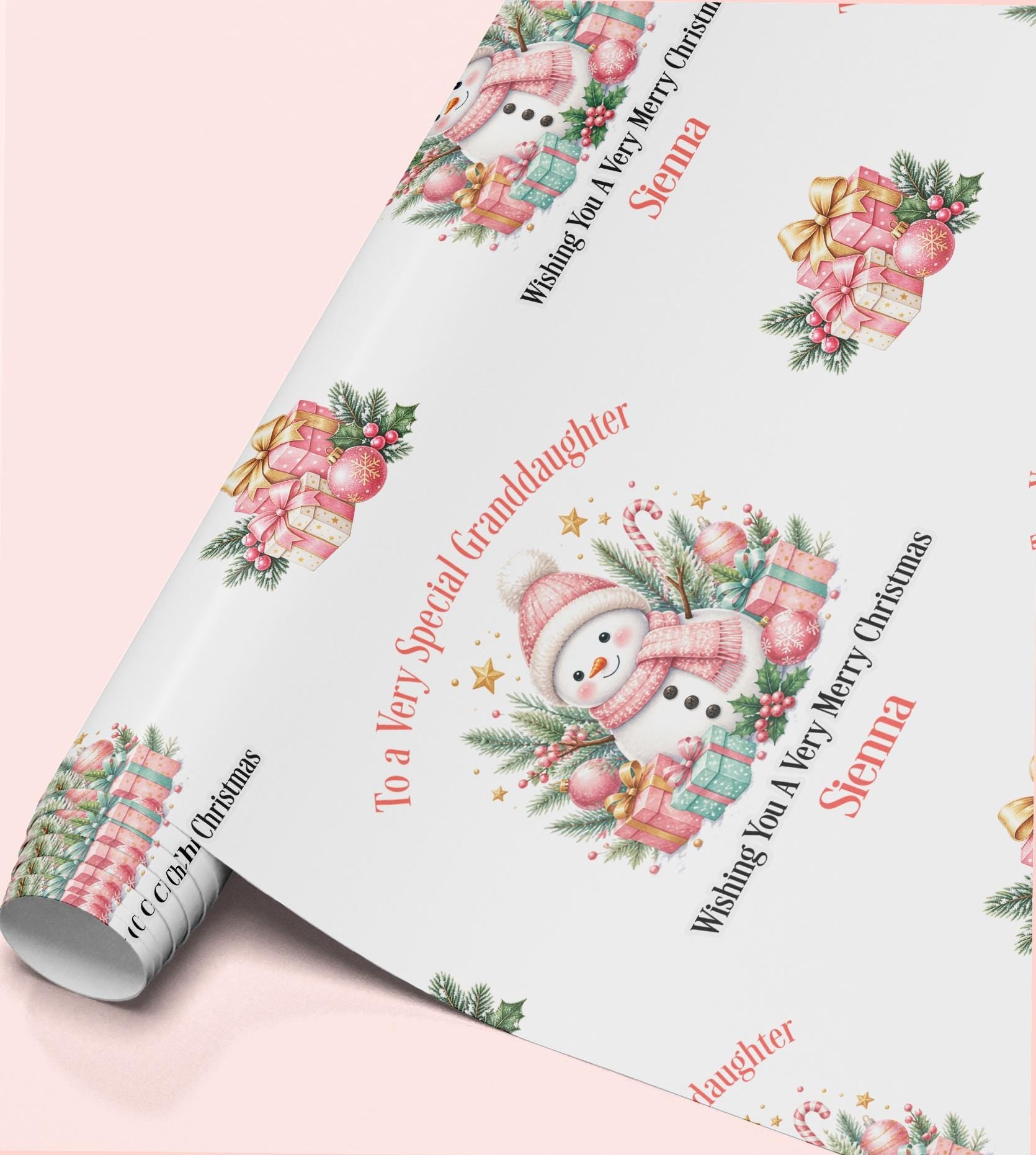 Rolled sheet of personalised pink snowman Christmas wrapping paper with a name and relation