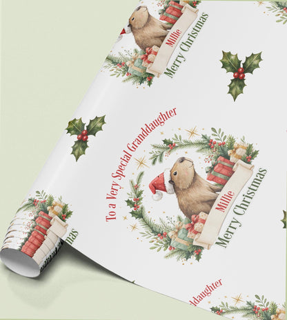 Rolled sheet of personalised Christmas wrapping paper with a holly wreath design and a name