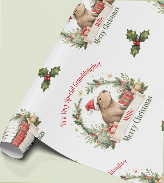 Rolled sheet of personalised Christmas wrapping paper with a holly wreath design and a name