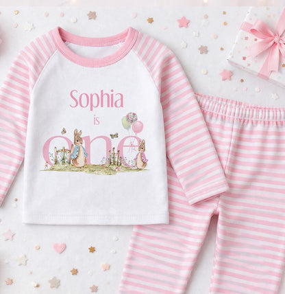 Personalised pink striped pyjamas with a grey bunny design and the child's name printed on the front
