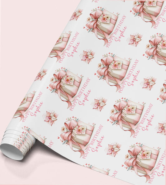 Personalised birthday wrapping paper featuring a pink gift box with floral ribbon, custom name and elegant pink flowers.