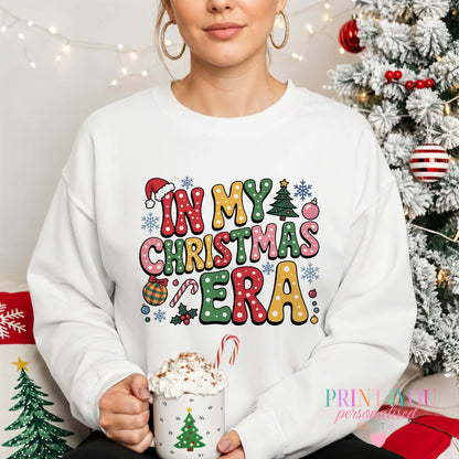 Woman wearing an "In My Christmas Era" retro ladies Christmas jumper with Santa hats, candy canes and snowflakes