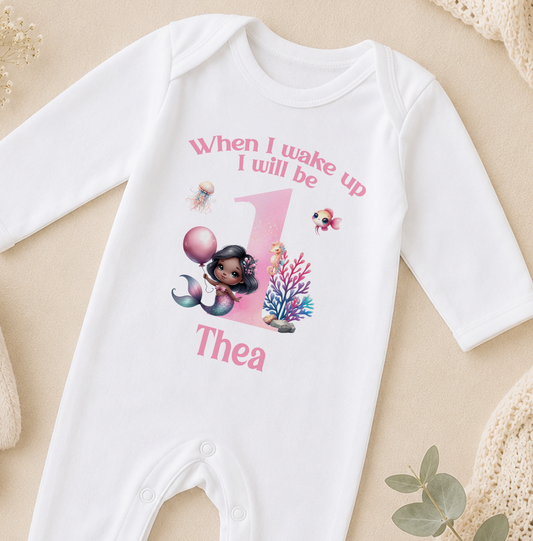 A white onesie with a mermaid design and the text "When I wake up I will be up" printed on it.