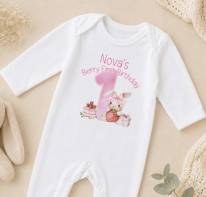 A white onesie with a pink bunny and a pink number 1 on it, along with the text "Nova's Berry First Birthday".