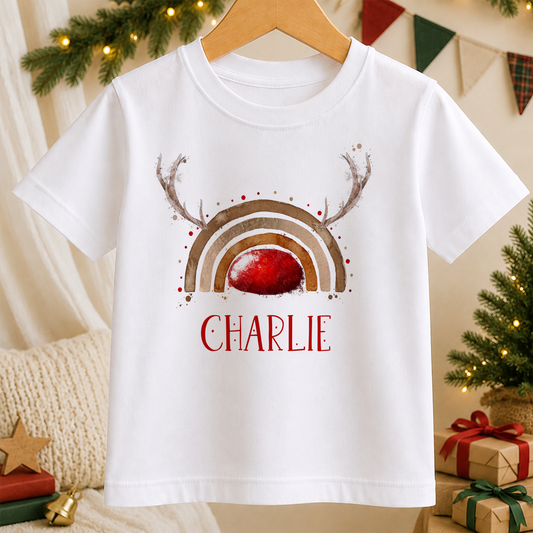 A white t-shirt with a colorful graphic design featuring a rainbow and antlers, along with the name "CHARLIE" printed on it.