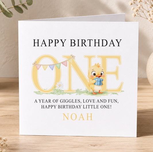 Square first birthday card for Noah featuring an illustrated yellow duck holding a blue gift, reading 'Happy Birthday Noah'.