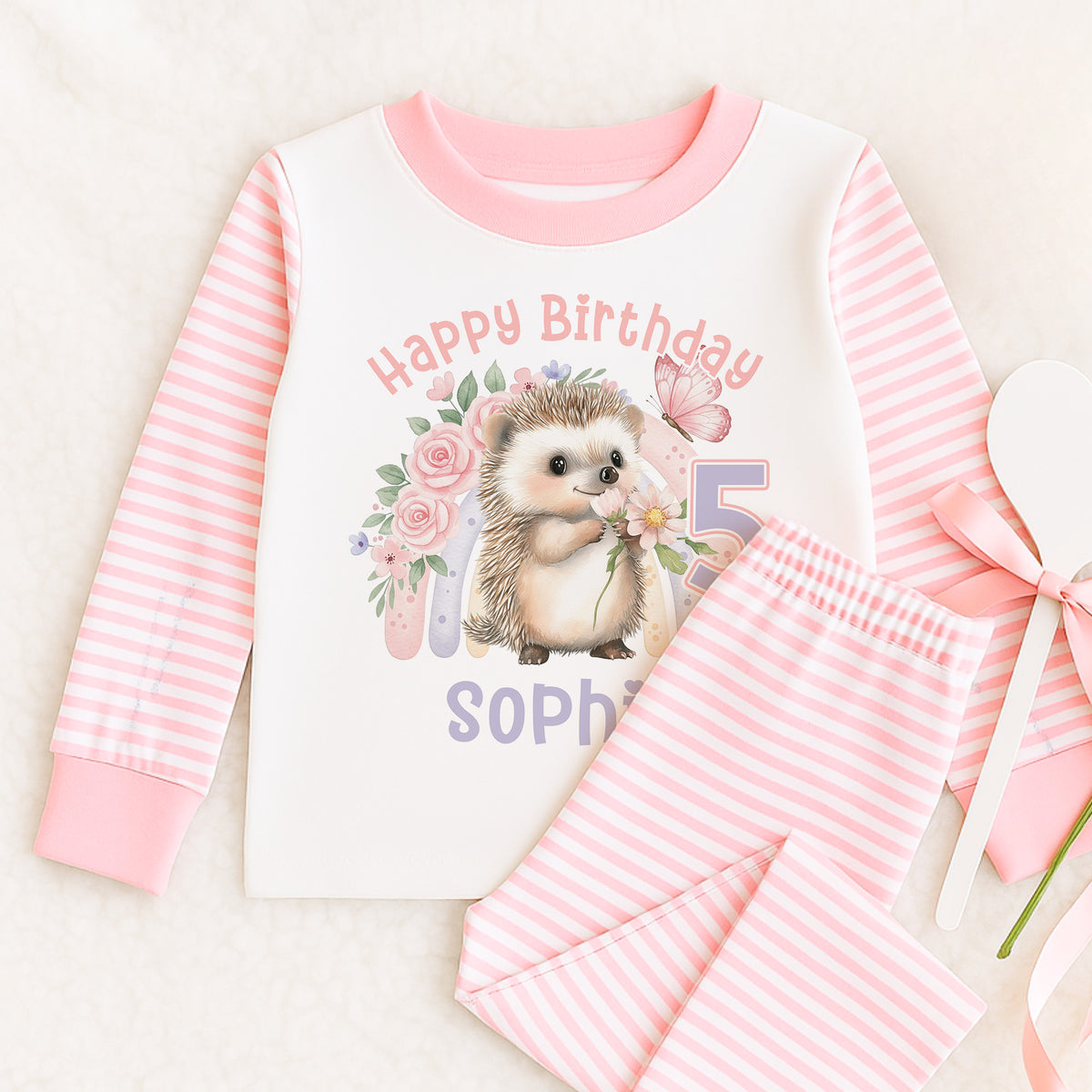 Personalised pink and white striped girls' pyjamas with rainbow hedgehog Happy Birthday design, size 6-12 months