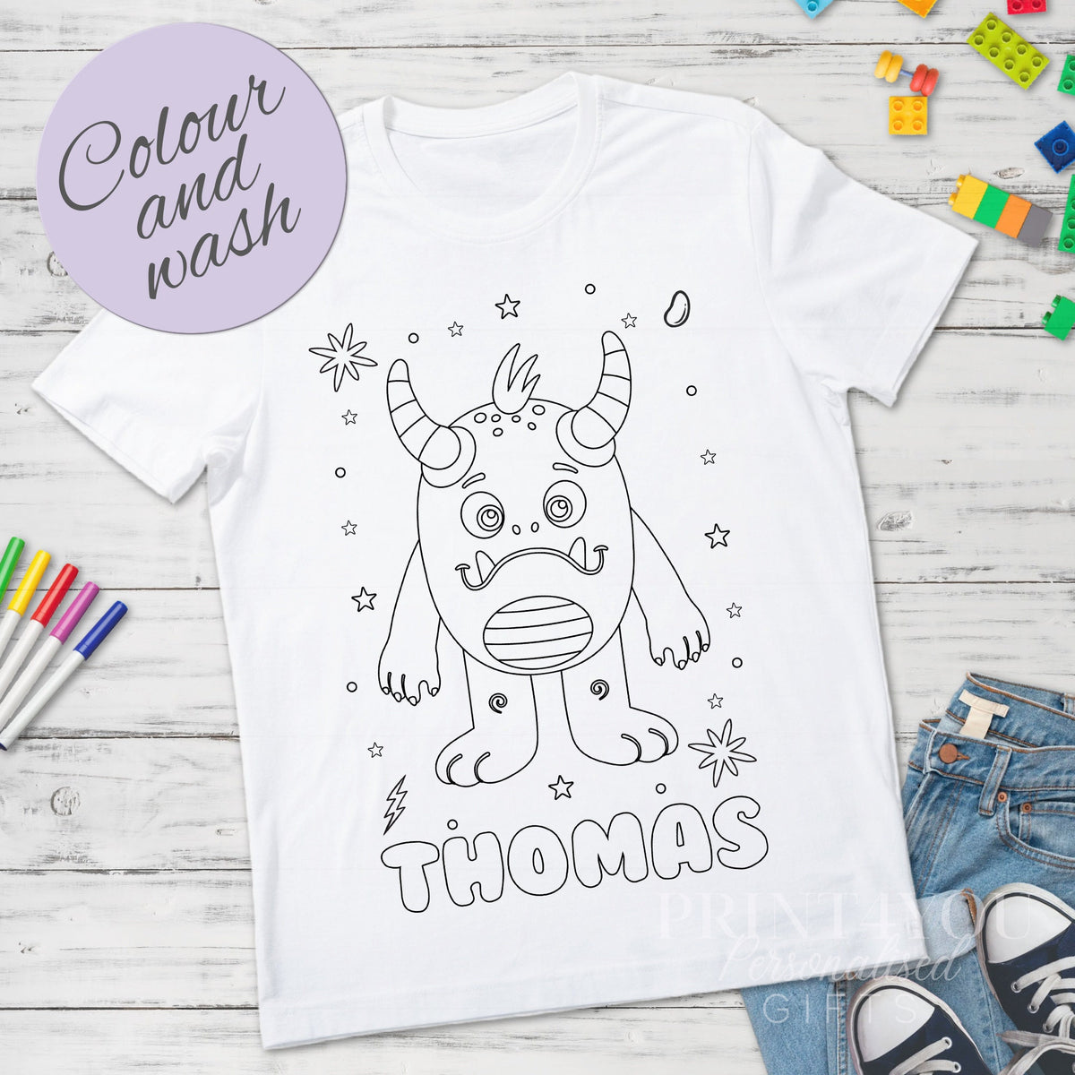 Kids' personalised monster colour-in activity t-shirt shown with washable colouring pens, size 1-2 years