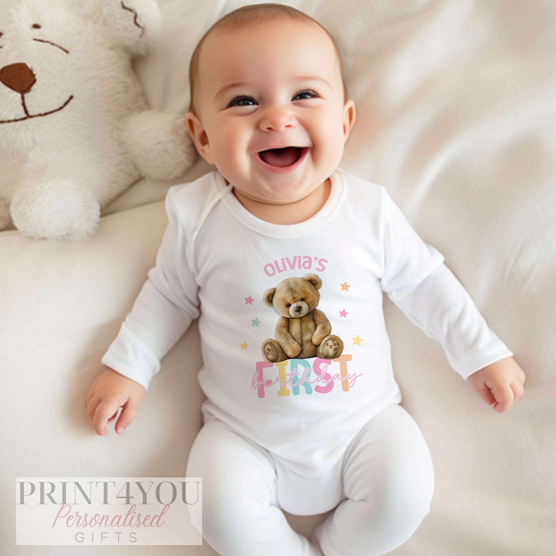 Range of personalised Girls Teddy Bear first birthday garments, including vest, sleepsuit and bib.