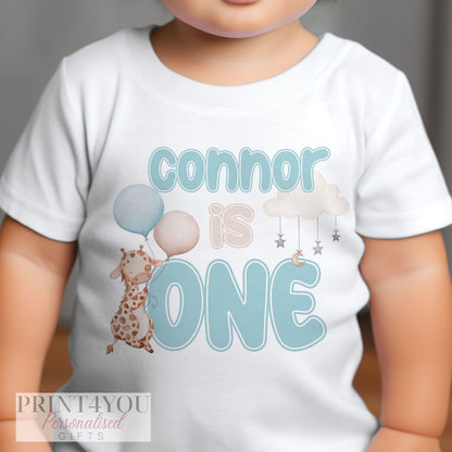 Baby wearing the personalised blue giraffe first birthday sleepsuit.