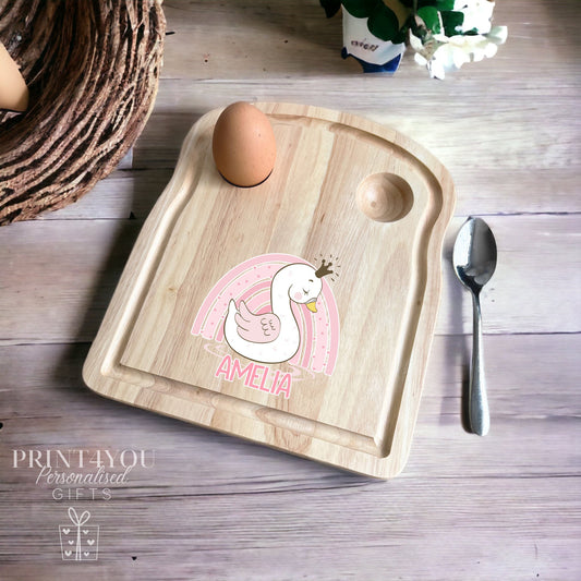 Wooden toast-shaped breakfast board with a princess swan and rainbow design and personalised name, with two egg holes for boiled eggs and soldiers