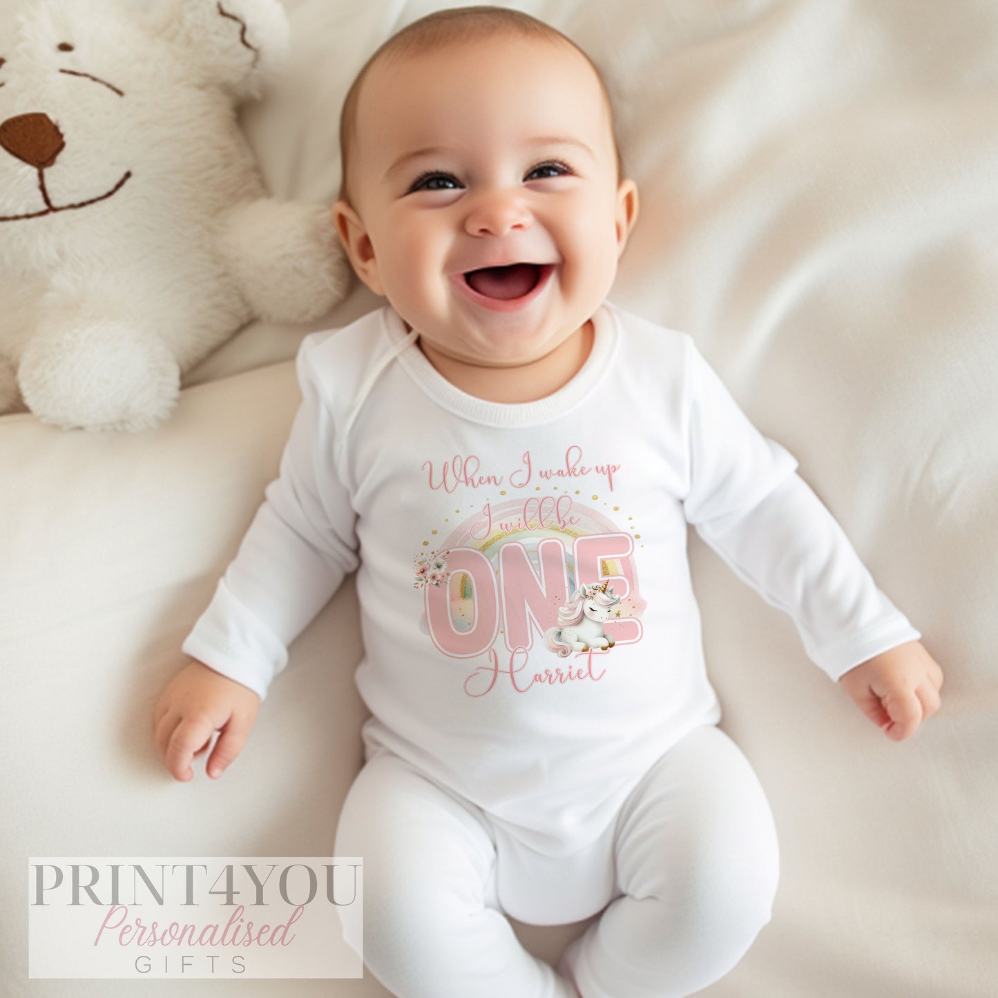 White cotton vest printed with a colourful unicorn and rainbow design and personalised baby name.