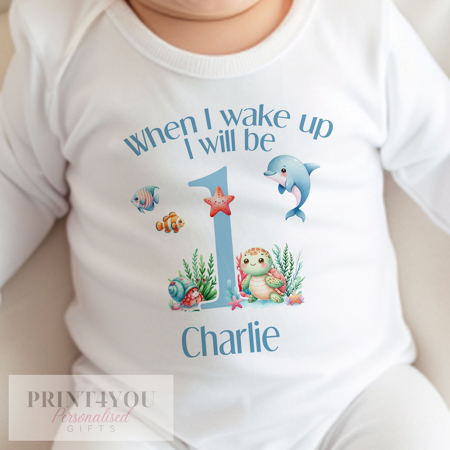 Personalised under the sea bib featuring dolphin and starfish artwork and the baby's name.