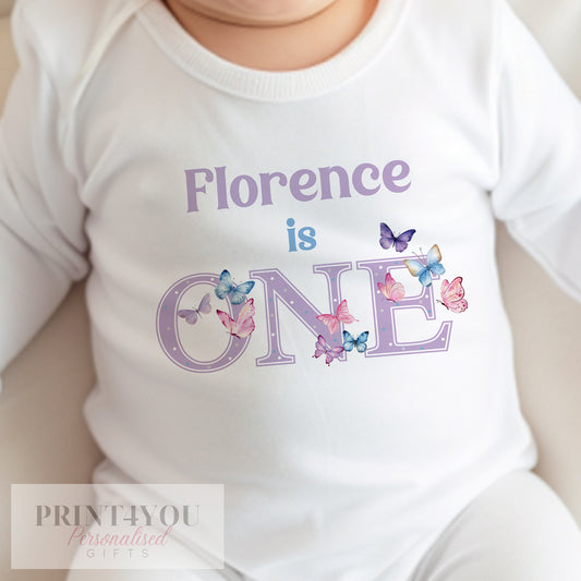 Personalised butterfly first birthday bib printed with 'I am one' and a custom name.