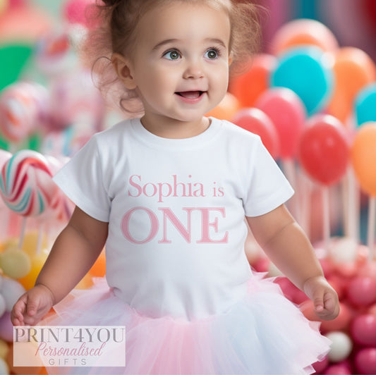 White personalised baby bib printed with the Pink First Birthday design.