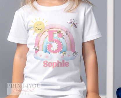 Personalised rainbow birthday t-shirt laid flat, showing the printed name and age.