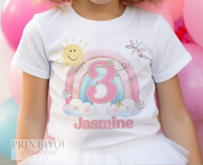 Close-up of the rainbow, sun and clouds print on a personalised birthday t-shirt.