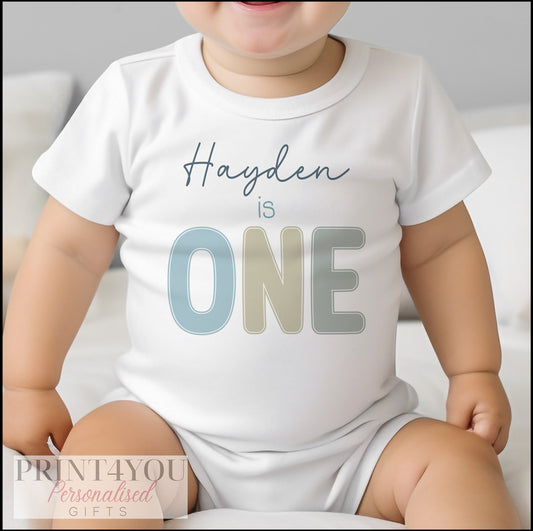 Personalised pastel baby bib printed with an 'I Am One' first birthday design.