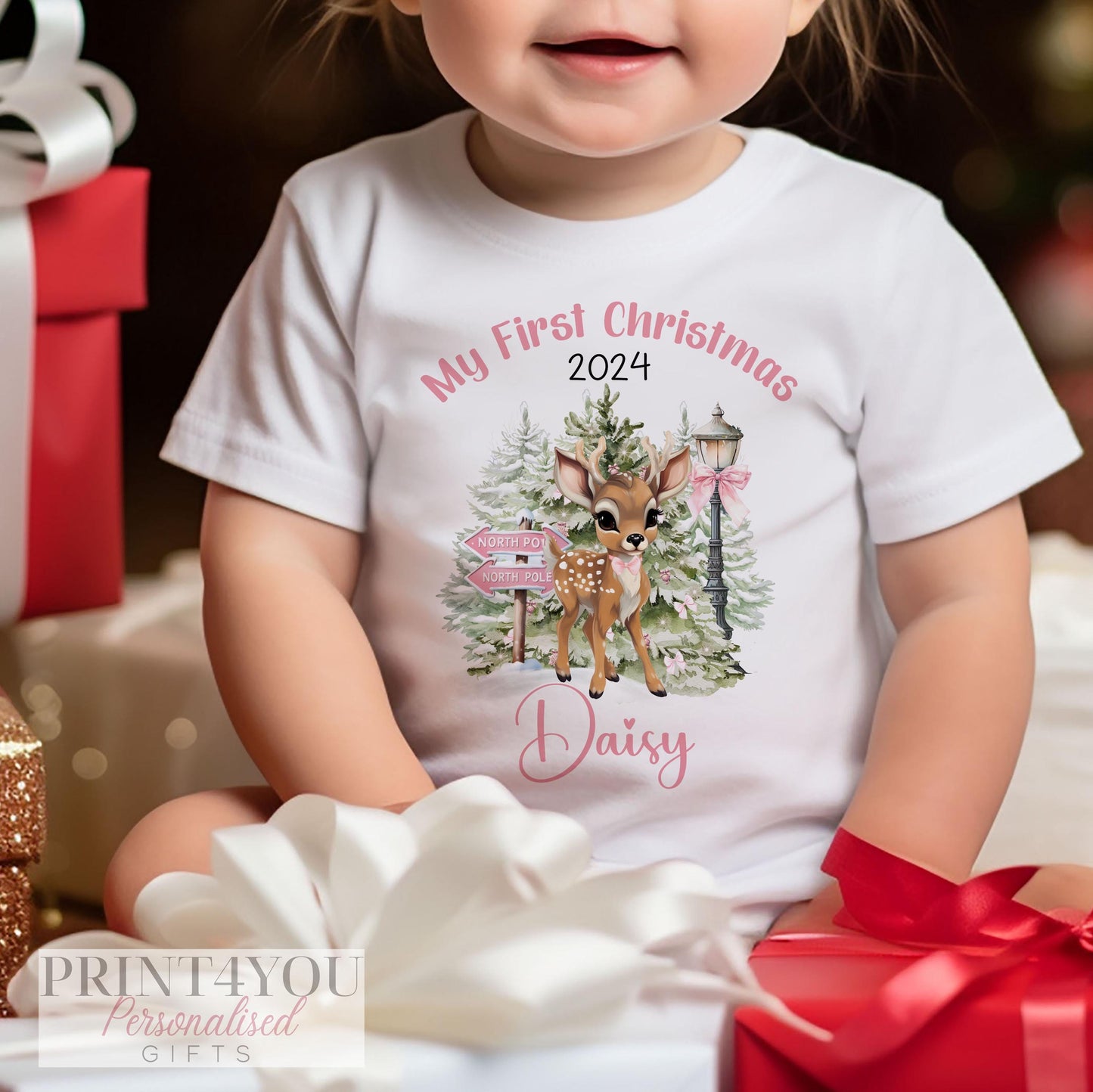 Personalised Pink Reindeer baby's first Christmas bib, vest and sleepsuit set, folded flat.