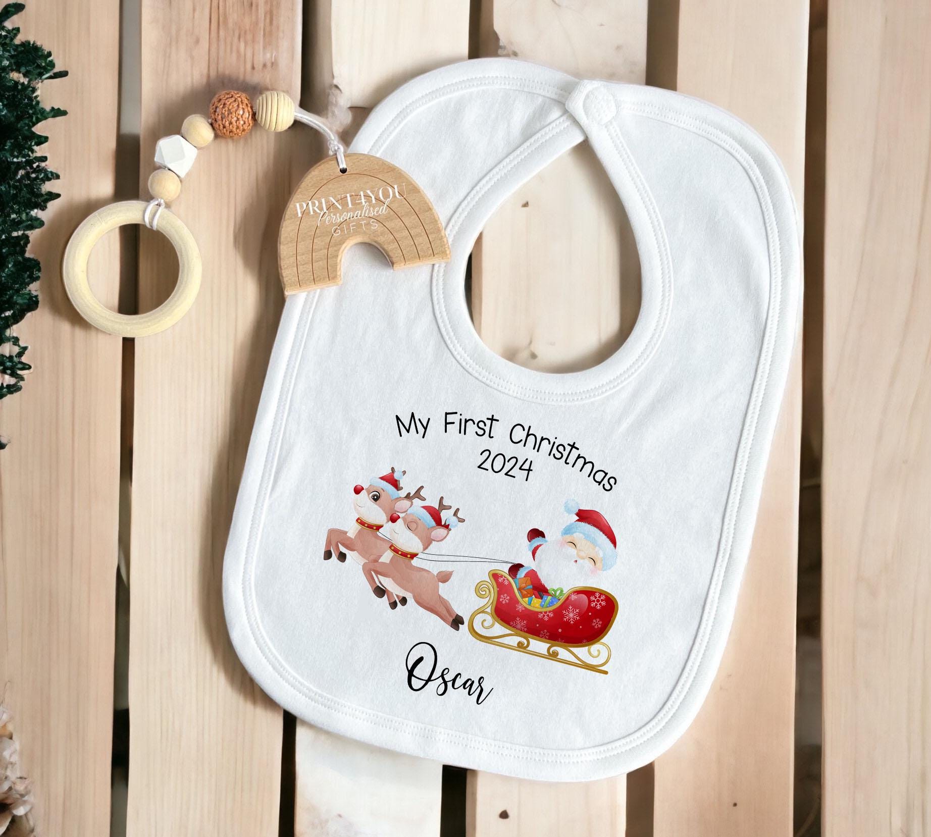 White cotton bib personalised with the Santa and Reindeer Sleigh first Christmas print.