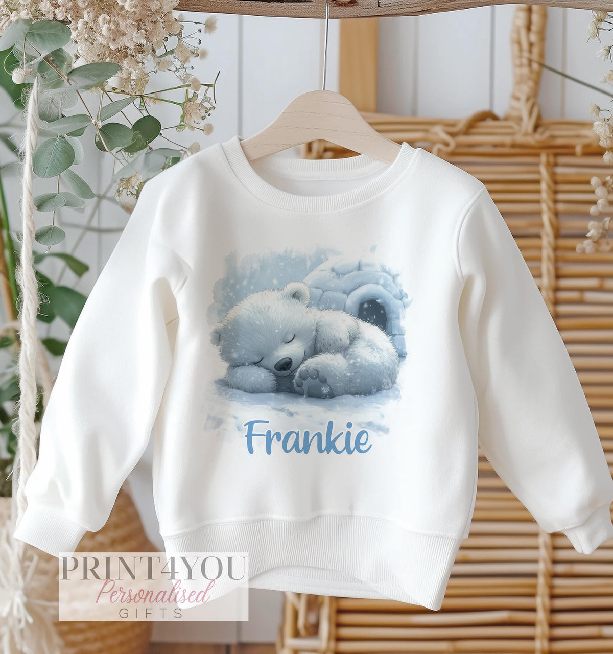 White cotton sweatshirt with a sleeping polar bear design beside an igloo, personalised with the name Frankie.