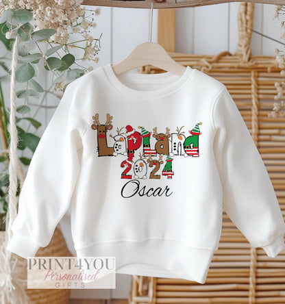 White Christmas jumper with Lapland 2024 festive alphabet design and personalised name, size 6-12 months