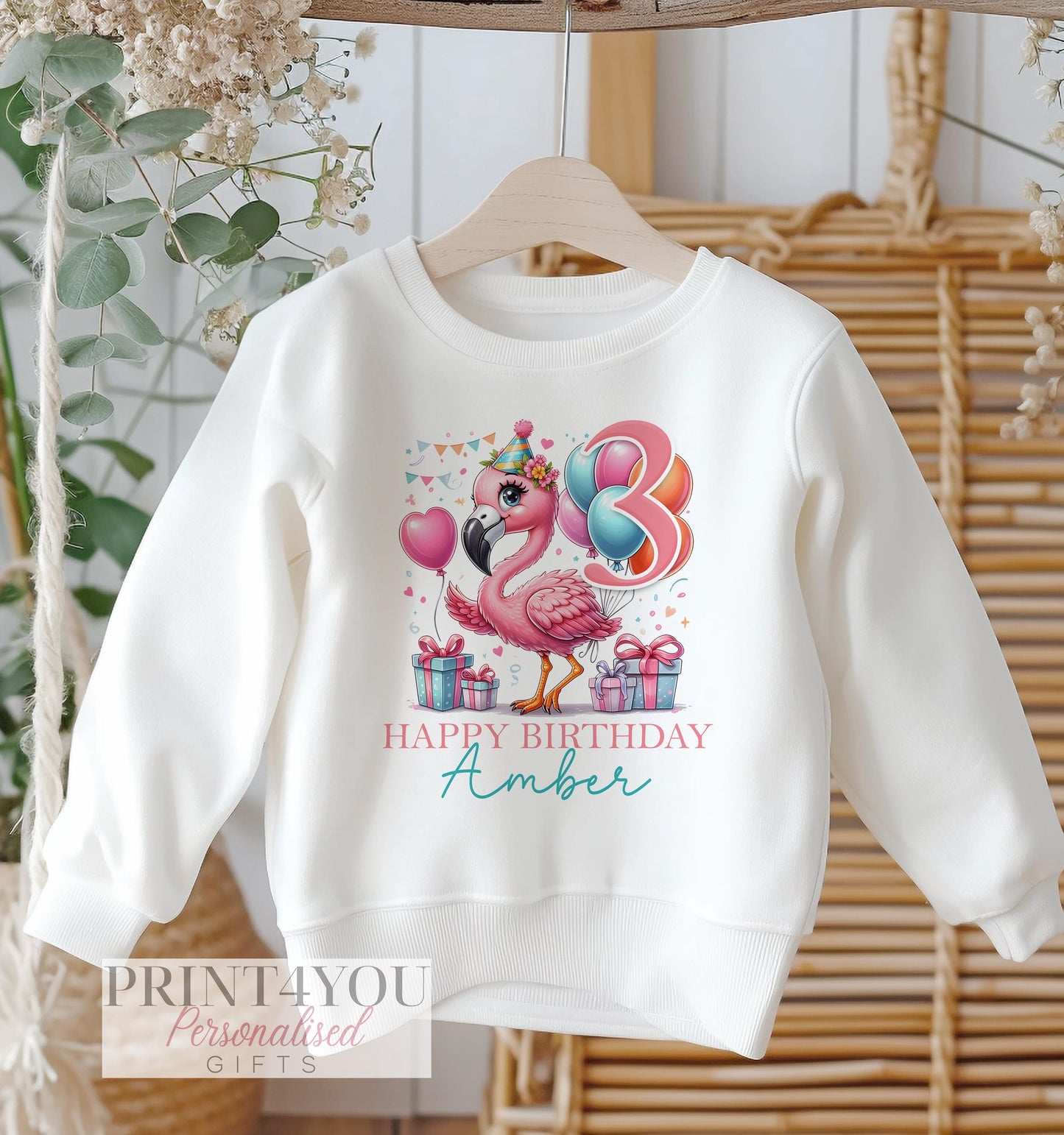 Personalised flamingo birthday design on a white cotton kids' sweatshirt, size 6-12 months.