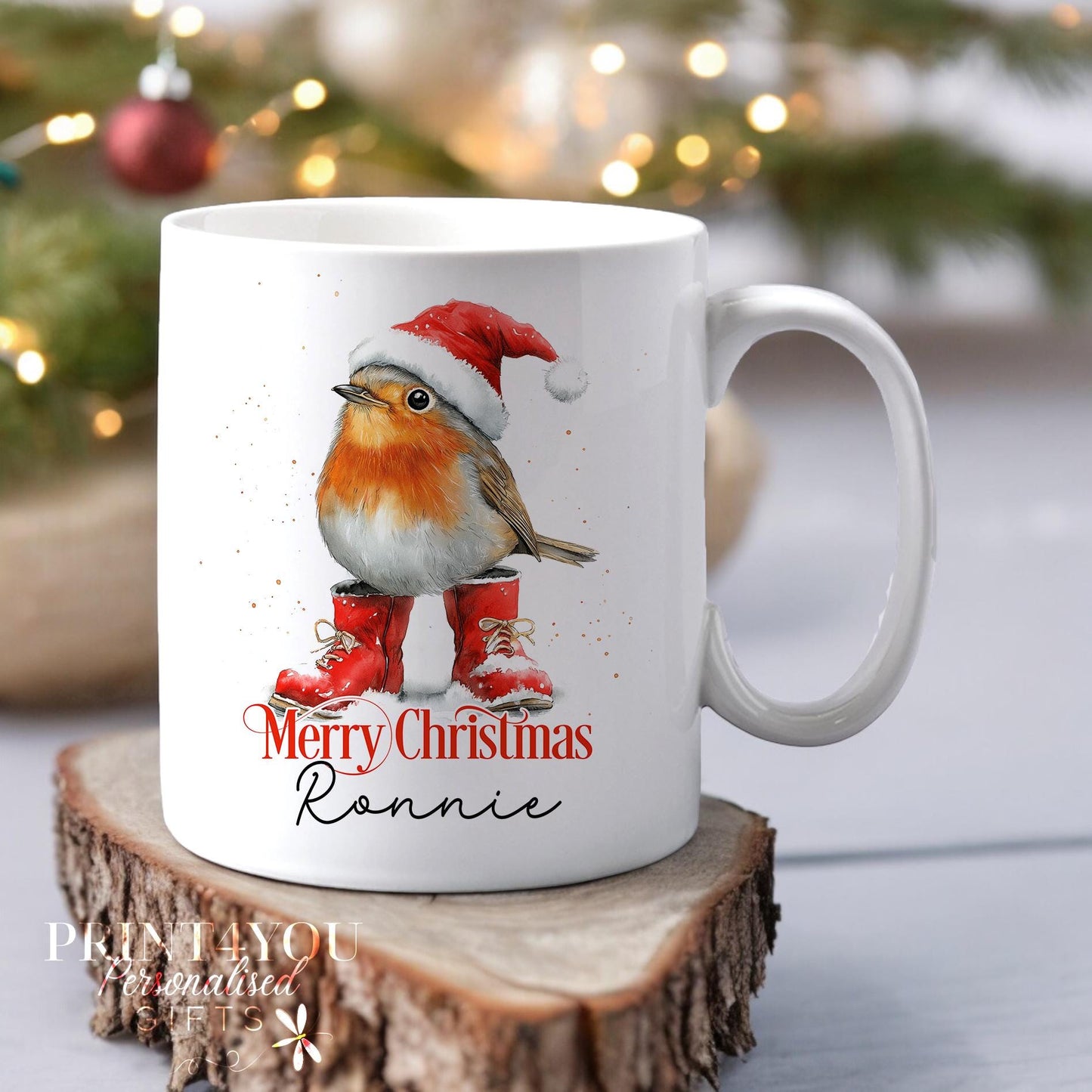 White ceramic mug personalised with 'Merry Christmas' and a custom name, featuring a festive robin wearing a Santa hat