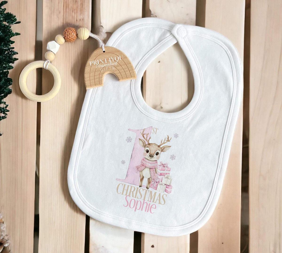 Personalised baby's first Christmas sleepsuit with a pink reindeer design and the baby's name.