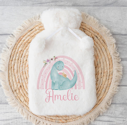 Fluffy white hot water bottle cover with a pastel rainbow dinosaur design, printed with the personalised name Amelie