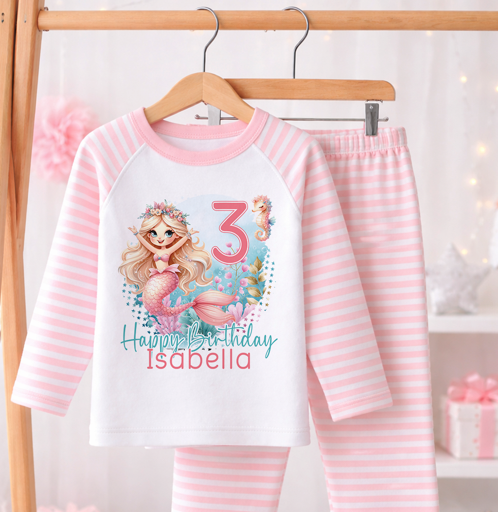 Pink and white striped pyjama set printed with a mermaid design, personalised name and age, laid flat against a white background