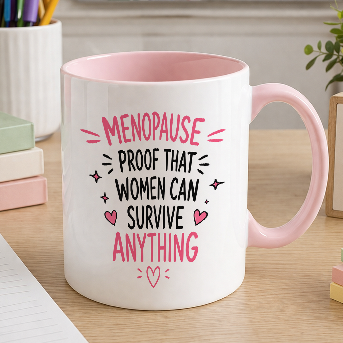 White ceramic mug with pink handle and pink inner printed with Menopause proof that women can survive anything