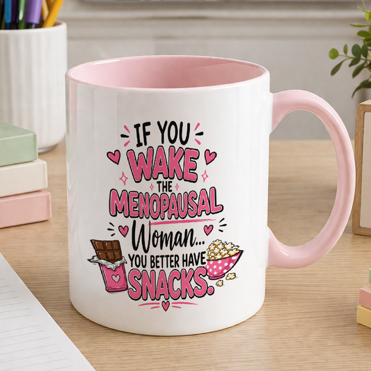 White ceramic mug with pink handle printed with the slogan If you wake the menopausal woman you better have snacks