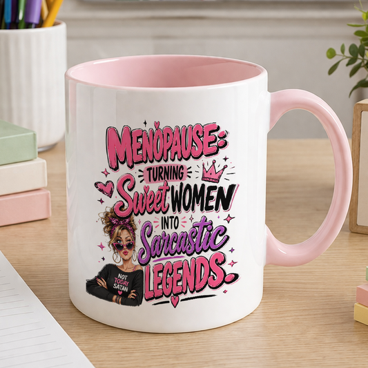 White ceramic mug with pink handle printed with the slogan Menopause turning sleepless women into dangerous legends