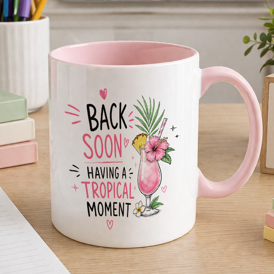 White ceramic mug with pink handle and pink inner, printed with a watercolour tropical cocktail and the text Back soon having a tropical moment