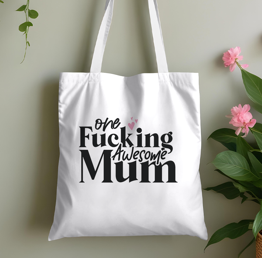 Plain pink cotton tote bag printed with a bold, cheeky adult-humour mum slogan, laid flat against a plain background
