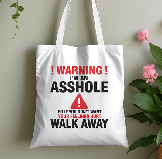 Plain cotton tote bag printed with a bold adult-humour warning slogan, laid flat against a plain background