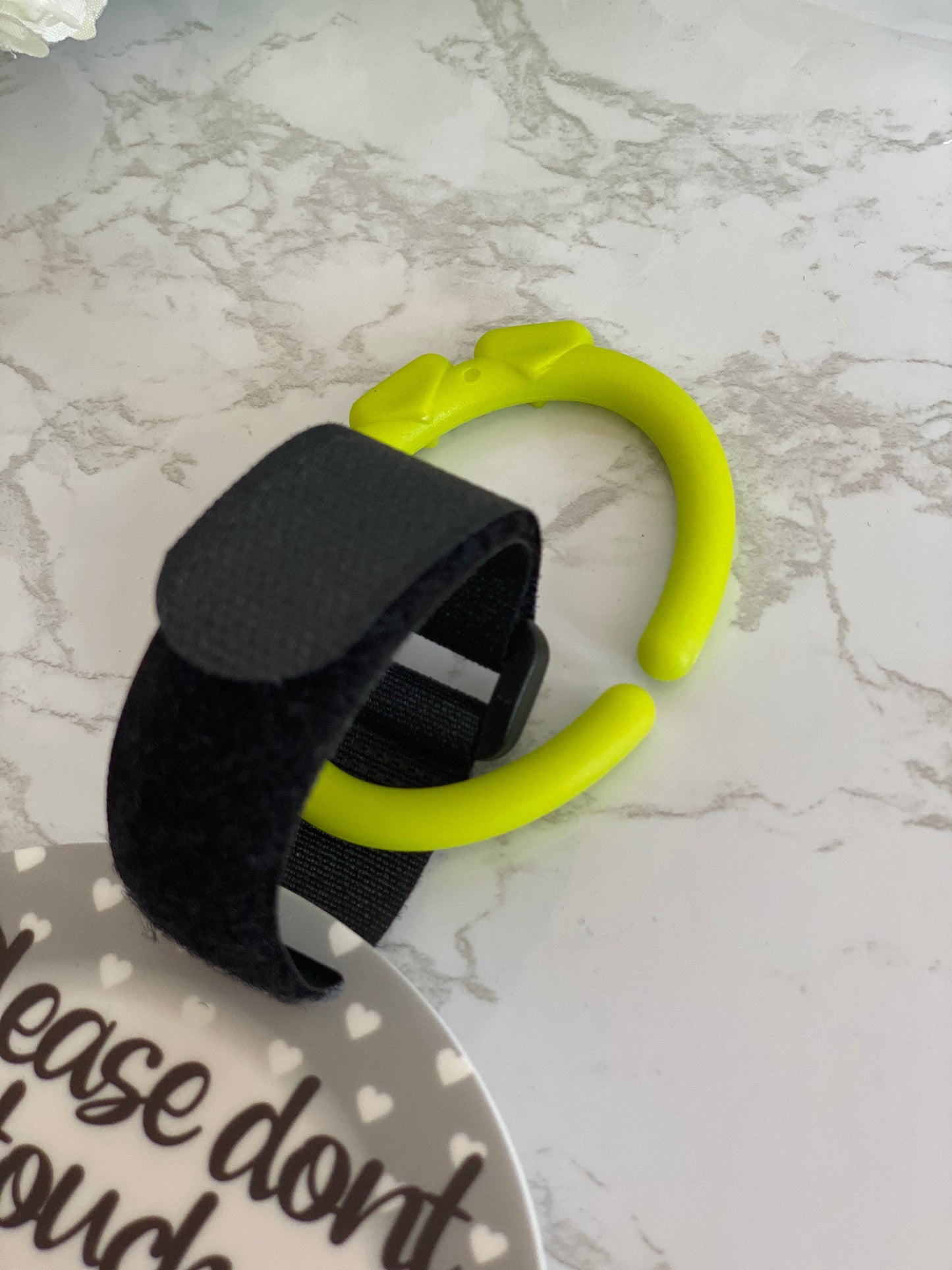 Pram tag safety sign shown attached to a pushchair or car seat handle