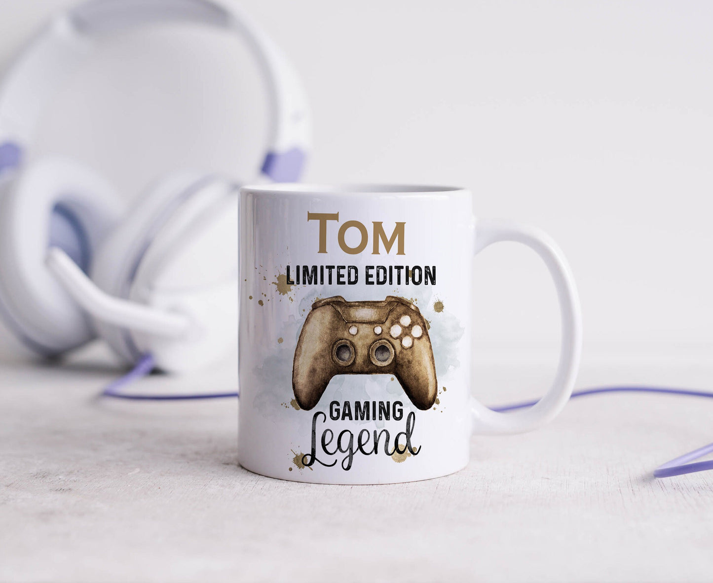 White ceramic mug with a gold games controller design and personalised name print