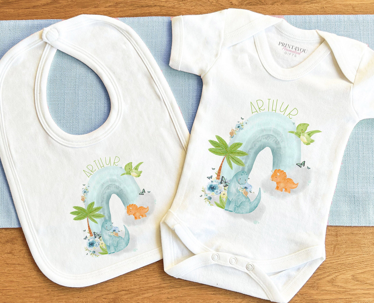 Close-up of the dinosaurs on a rainbow design with personalised name text.